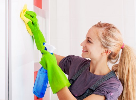 Technician preparing carpet cleaning equipment with safety measures in a Holland Park property